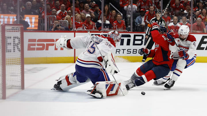 Apr 23, 2025; Washington, District of Columbia, USA; Montreal Canadiens goaltender Sam Montembeault (35) makes a save on Washington Capitals left wing Andrew Mangiapane (88) as Canadiens defenseman Alexandre Carrier (45) defends in the third period in game two of the first round of the 2025 Stanley Cup Playoffs at Capital One Arena. Mandatory Credit: Geoff Burke-Imagn Images