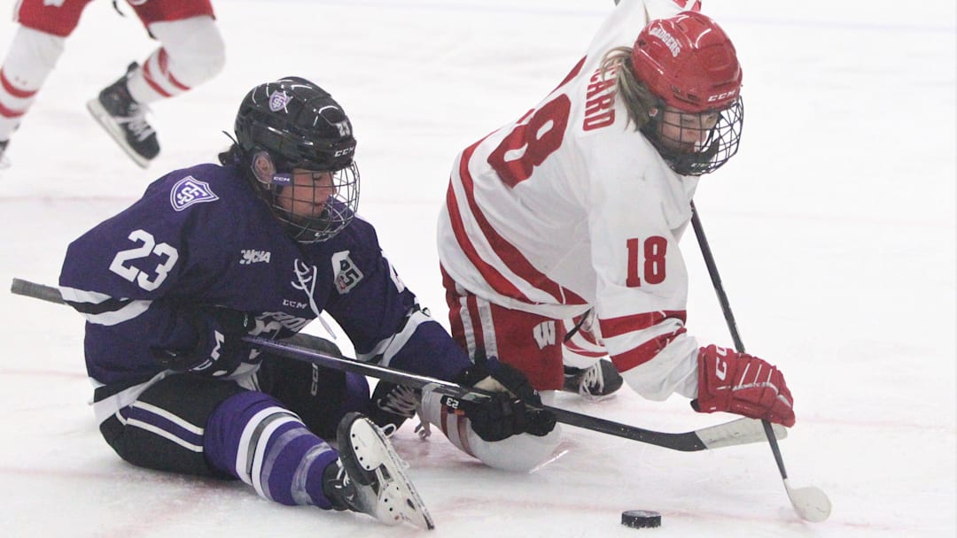 Wisconsin's Marianne Picard (18) fights for the puck after a faceoff with St. Thomas' Brieja Parent on Saturday March 2, 2024 at LaBahn Arena in Madison, Wisconsin.