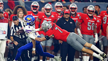 Dec 26, 2023; Phoenix, AZ, USA; Kansas Jayhawks quarterback Jason Bean (9) runs the ball against UNLV Rebels linebacker Jackson Woodard (7) during the second quarter in the Guaranteed Rate Bowl at Chase Field. Mandatory Credit: Mark J. Rebilas-Imagn Images