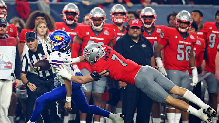 Dec 26, 2023; Phoenix, AZ, USA; Kansas Jayhawks quarterback Jason Bean (9) runs the ball against UNLV Rebels linebacker Jackson Woodard (7) during the second quarter in the Guaranteed Rate Bowl at Chase Field. Mandatory Credit: Mark J. Rebilas-Imagn Images