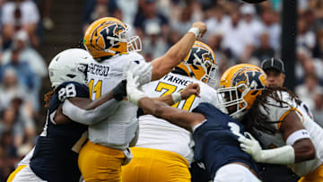 JD Sherrod #11 of the Kent State Golden Flashes is hit by Zane Durant #28 of the Penn State Nittany Lions as he attempts a pass during the first half at Beaver Stadium on September 21, 2024 in State College, Pennsylvania.