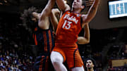 Jan 4, 2025; Blacksburg, Virginia, USA; Virginia Tech Hokies forward Ben Burnham (13) shoots the ball against Miami Hurricanes forward Isaiah Johnson-Arigu (4) during the first half at Cassell Coliseum. Mandatory Credit: Peter Casey-Imagn Images