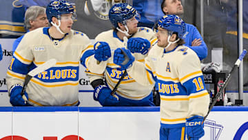Feb 8, 2025; St. Louis, Missouri, USA;  St. Louis Blues center Robert Thomas (18) is congratulated by left wing Jake Neighbours (63) and center Dylan Holloway (81) after scoring the game tying goal against the Chicago Blackhawks during the third period at Enterprise Center. Mandatory Credit: Jeff Curry-Imagn Images