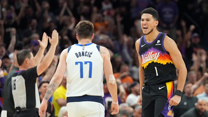 Phoenix Suns guard Devin Booker reacts after a three point basket against Dallas Mavericks guard Luka Doncic. Phoenix Suns guard Devin Booker reacts after a three point basket against Dallas Mavericks guard Luka Doncic.