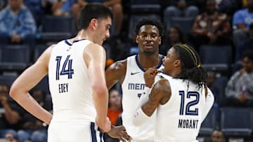 Oct 30, 2024; Memphis, Tennessee, USA; Memphis Grizzlies guard Ja Morant (12) talks with center Zach Edey (14) and forward Jaren Jackson Jr. (13) during the first half against the Brooklyn Nets at FedExForum. Mandatory Credit: Petre Thomas-Imagn Images