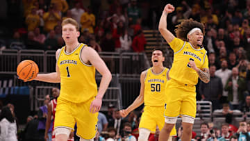 Danny Wolf #1, Tre Donaldson #3 and Vladislav Goldin #50 of the Michigan Wolverines celebrate after winning the Big Ten men's basketball tournament championship at Gainbridge Fieldhouse on March 16, 2025 in Indianapolis, Indiana.