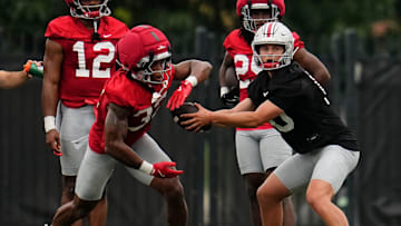 Ohio State Buckeyes Julian Sayin hands off the ball to running back Isaiah West.