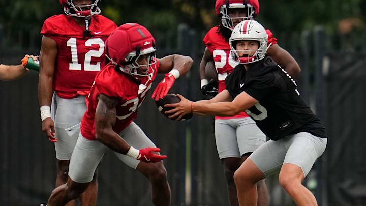 Ohio State Buckeyes Julian Sayin hands off the ball to running back Isaiah West.