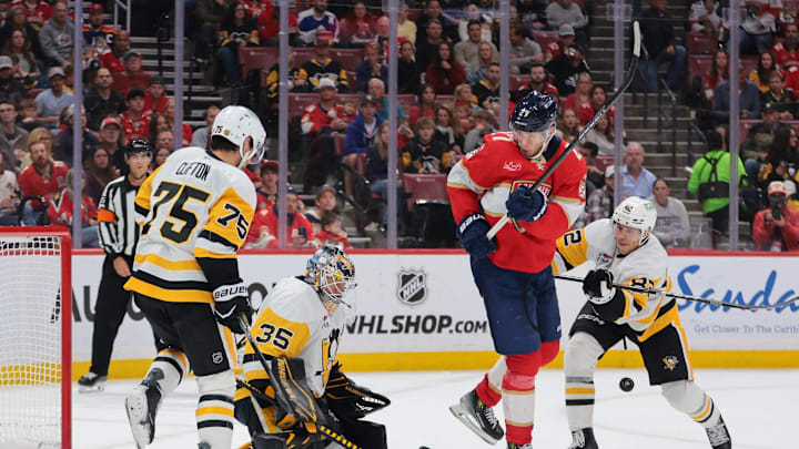Oct 23, 2025; Sunrise, Florida, USA; Florida Panthers center Eetu Luostarinen (27) shoots the puck against Pittsburgh Penguins goaltender Tristan Jarry (35) as defenseman Connor Clifton (75) and defenseman Caleb Jones (82) defend during the second period at Amerant Bank Arena. Mandatory Credit: Sam Navarro-Imagn Images