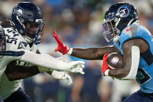 Tennessee Titans running back Hassan Haskins (25) powers his way forward against Seattle's Jamie Sheriff (44).