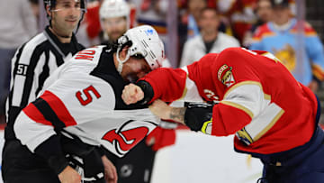New Jersey Devils defenseman Brenden Dillon (5) and Florida Panthers left wing Jonah Gadjovich (12) fight. Mandatory Credit: Sam Navarro-Imagn Images