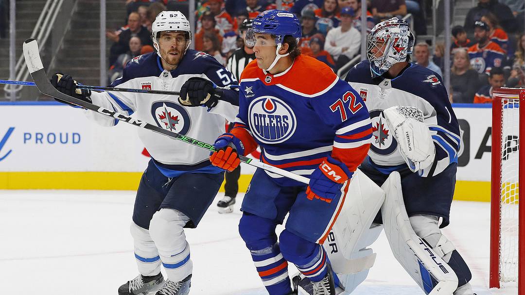 Sep 22, 2024; Edmonton, Alberta, CAN; Edmonton Oilers forward Sam O'Reilly (72) tries to screen Winnipeg Jets goaltender Eric Comrie (1) during the first period at Rogers Place. Mandatory Credit: Perry Nelson-Imagn Images