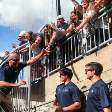 Penn State football coach James Franklin high-fives students after a Nittany Lions victory at Beaver Stadium.