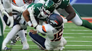 Oct 12, 2025; Tottenham, United Kingdom; New York Jets quarterback Justin Fields (7) is tackled by Denver Broncos linebacker Nik Bonitto (15) during an NFL International Series game at Tottenham Hotspur Stadium. 