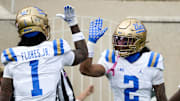 Oct 11, 2025; East Lansing, Michigan, USA; UCLA Bruins wide receiver Titus Mokiao-Atimalala (2) celebrates a touchdown with wide receiver Rico Flores Jr. (1) in the second quarter at Spartan Stadium. Mandatory Credit: Brendan Mullin-Imagn Images