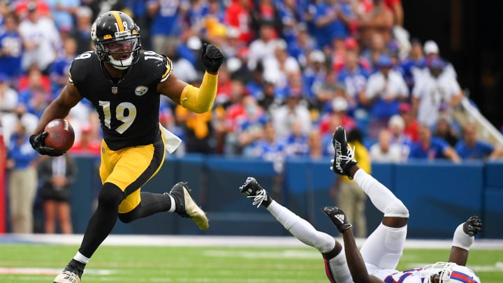 Sep 12, 2021; Orchard Park, New York, USA; Pittsburgh Steelers wide receiver JuJu Smith-Schuster (19) runs with the ball past Buffalo Bills cornerback Tre'Davious White (27) during the first half at Highmark Stadium. Mandatory Credit: Rich Barnes-USA TODAY Sports