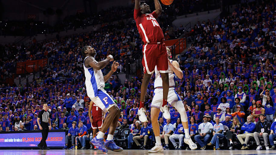 Alabama center Charles Bediako dunks the ball over Florida center Rueben Chinyelu.