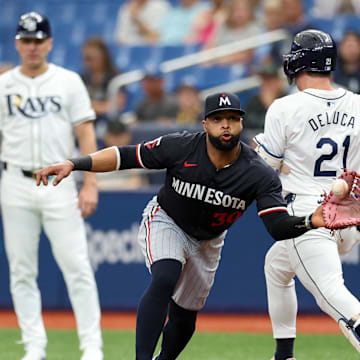 Tampa Bay Rays outfielder Jonny DeLuca (21) runs out an errant throw to Minnesota Twins first baseman Carlos Santana (30) in the third inning at Tropicana Field in St. Petersburg, Fla., on Sept. 5, 2024.