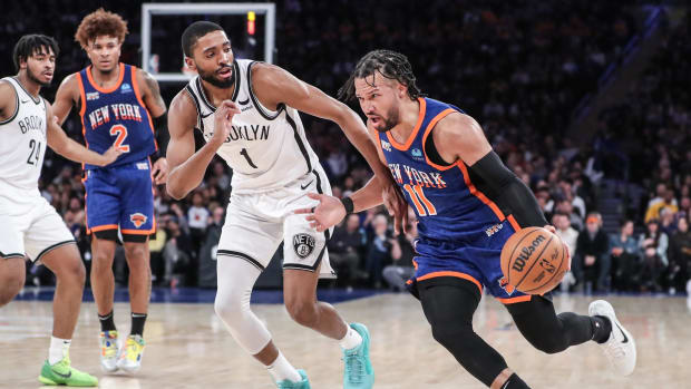 New York Knicks guard Jalen Brunson (11) drives past Brooklyn Nets forward Mikal Bridges (1) during a game.