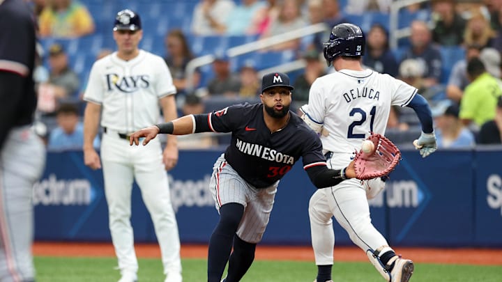 Tampa Bay Rays outfielder Jonny DeLuca (21) runs out an errant throw to Minnesota Twins first baseman Carlos Santana (30) in the third inning at Tropicana Field in St. Petersburg, Fla., on Sept. 5, 2024.