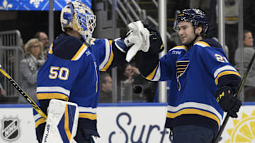 Apr 15, 2025; St. Louis, Missouri, USA; St. Louis Blues right wing Jimmy Snuggerud (21) and goaltender Jordan Binnington (50) celebrate a win against the Utah Hockey Club at Enterprise Center to clinch a spot in the playoffs. Mandatory Credit: Jeff Le-Imagn Images