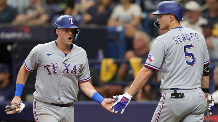 Oct 4, 2023; St. Petersburg, Florida, USA; Texas Rangers third baseman Josh Jung (6) high fives shortstop Corey Seager (5) after scoring a run against the Tampa Bay Rays in the sixth inning during game two of the Wildcard series for the 2023 MLB playoffs at Tropicana Field. Mandatory Credit: Nathan Ray Seebeck-USA TODAY Sports