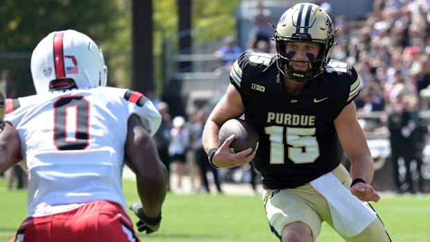 Purdue Boilermakers quarterback Ryan Browne (15) looks for a way around Ball State Cardinals linebacker Alfred Chea (0) 
