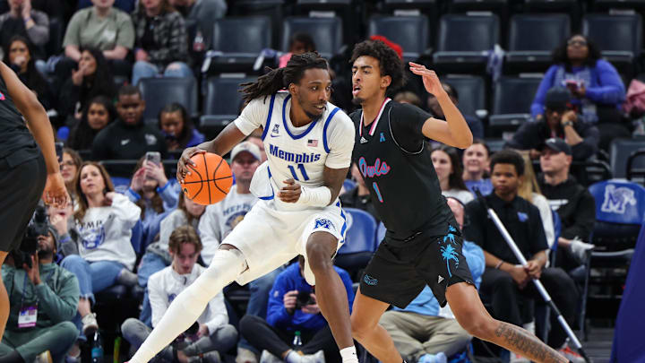 Jan 29, 2026; Memphis, Tennessee, USA; Memphis Tigers forward Aaron Bradshaw (11) drives against Florida Atlantic Owls forward Devin Williams (1) during the second half at FedExForum. Mandatory Credit: Wesley Hale-Imagn Images