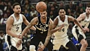 Oct 30, 2021; Milwaukee, Wisconsin, USA; Milwaukee Bucks guard George Hill (3) and San Antonio Spurs guard Bryn Forbes (7) and guard Devin Vassell (24) chase a loose ball in the second quarter at Fiserv Forum. Mandatory Credit: Benny Sieu-Imagn Images