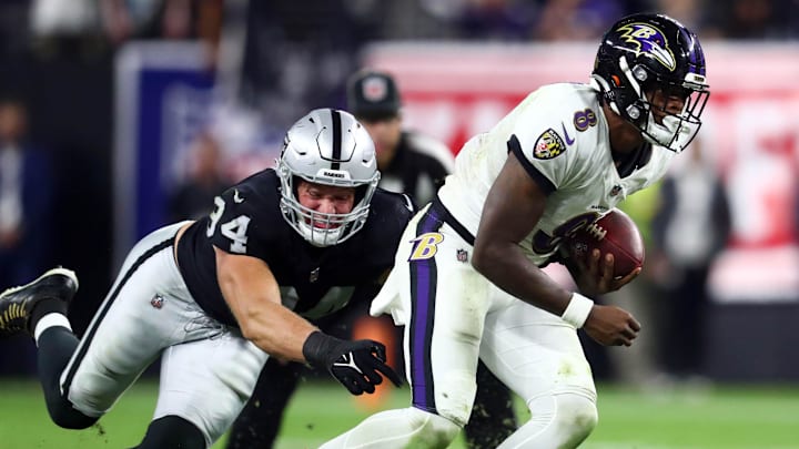 Sep 13, 2021; Paradise, Nevada, USA; Baltimore Ravens quarterback Lamar Jackson (8) runs the ball ahead of Las Vegas Raiders defensive end Carl Nassib (94) during the second half at Allegiant Stadium. Mandatory Credit: Mark J. Rebilas-Imagn Images