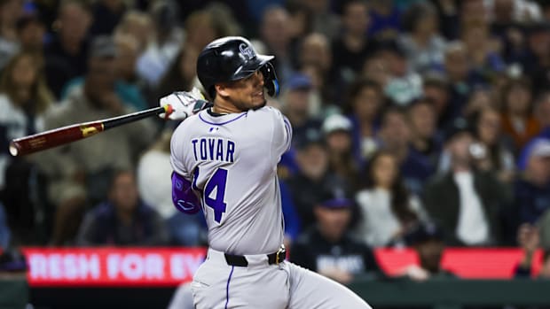 Colorado Rockies player Ezequiel Tovar swings the bat wearing a gray jersey and black helmet.