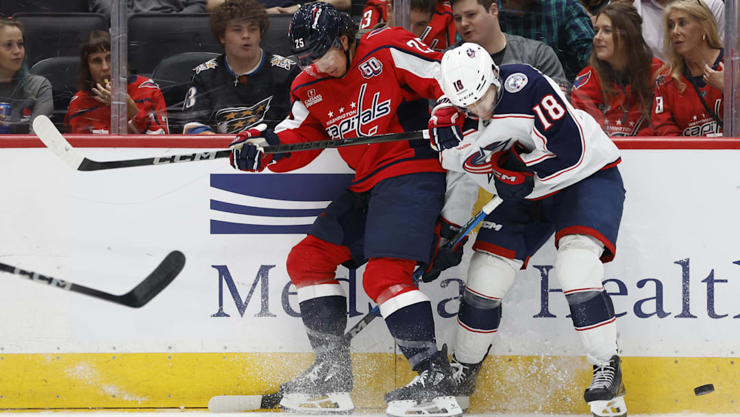 Sep 27, 2024; Washington, District of Columbia, USA; Washington Capitals defenseman Ethan Bear (25) and Columbus Blue Jackets center Dylan Gambrell (18) battle for the puck in the second period at Capital One Arena. Mandatory Credit: Geoff Burke-Imagn Images