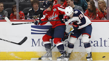 Sep 27, 2024; Washington, District of Columbia, USA; Washington Capitals defenseman Ethan Bear (25) and Columbus Blue Jackets center Dylan Gambrell (18) battle for the puck in the second period at Capital One Arena. Mandatory Credit: Geoff Burke-Imagn Images
