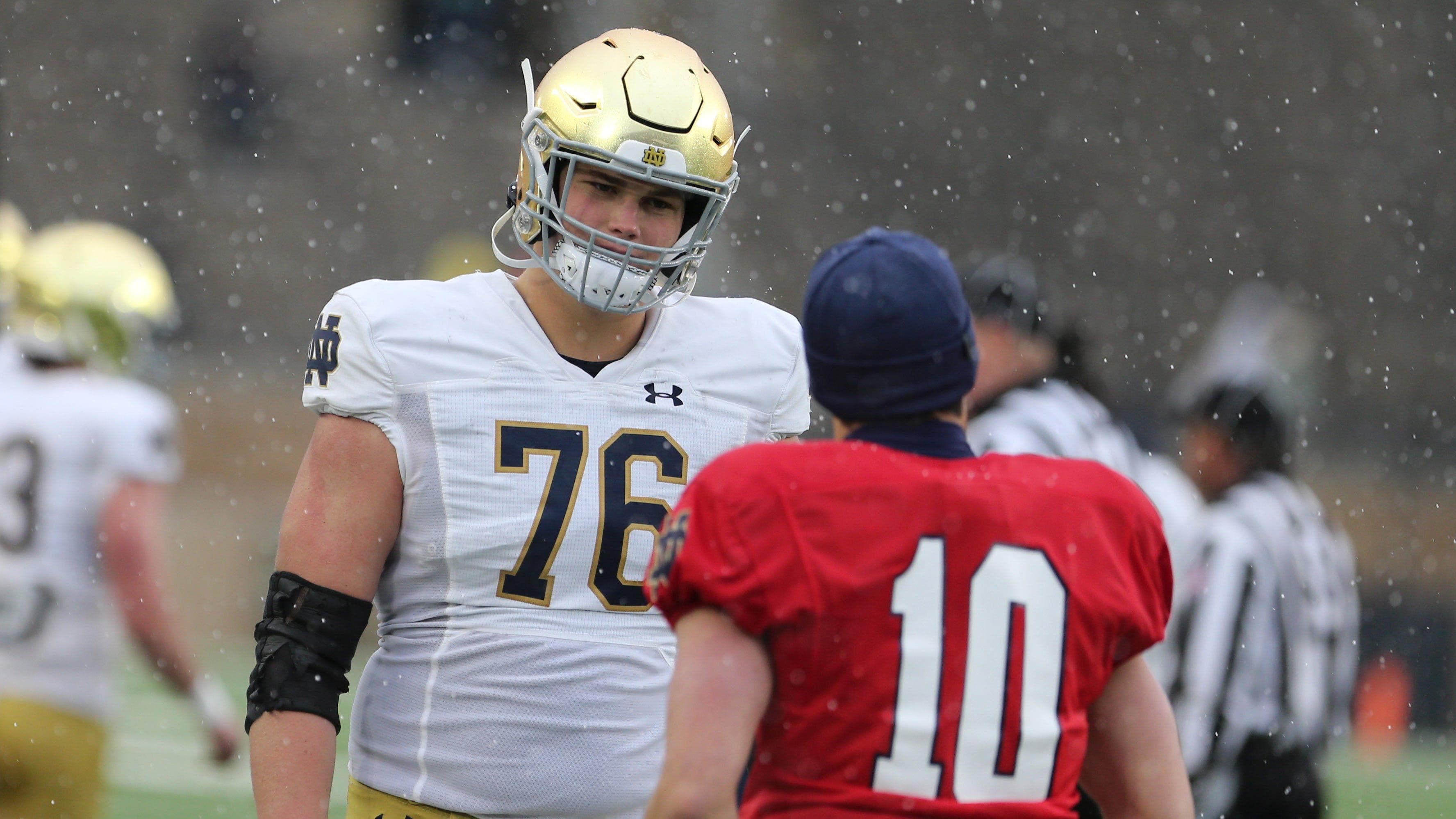 Joe Alt is one massive human being with athleticism and towers over his Notre Dame QB Sam Hartman.