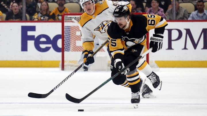 Apr 15, 2024; Pittsburgh, Pennsylvania, USA;  Pittsburgh Penguins defenseman Erik Karlsson (65) moves the puck ahead of Nashville Predators right wing Michael McCarron (47) during the first period  at PPG Paints Arena. Mandatory Credit: Charles LeClaire-Imagn Images