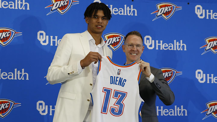 Jun 25, 2022; Oklahoma City, OK, USA; Oklahoma City Thunder forward Ousmane Dieng poses with his jersey and general manager Sam Presti following an introductory press conference at Clara Luper Center. Mandatory Credit: Alonzo Adams-Imagn Images