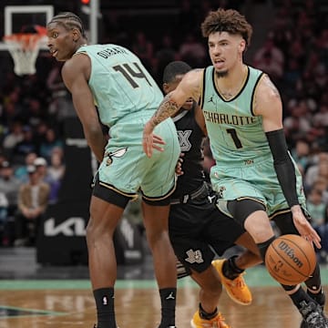 Feb 7, 2025; Charlotte, North Carolina, USA; Charlotte Hornets guard LaMelo Ball (1) dribbles around a pick by forward Moussa Diabate (14) against the San Antonio Spurs during the first quarter at Spectrum Center. Mandatory Credit: Jim Dedmon-Imagn Images