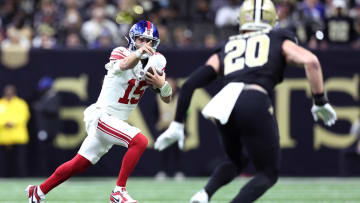 Dec 17, 2023; New Orleans, Louisiana, USA; New York Giants quarterback Tommy DeVito (15) runs the ball while defended by New Orleans Saints linebacker Pete Werner (20) during the first half at Caesars Superdome. Mandatory Credit: Stephen Lew-USA TODAY Sports