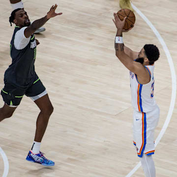 May 20, 2025; Oklahoma City, Oklahoma, USA; Oklahoma City Thunder forward Kenrich Williams (right) shoots against Minnesota Timberwolves center Naz Reid (left) in the third quarter during Game 1 of the Western Conference Finals at Paycom Center. Mandatory Credit: Brett Rojo-Imagn Images