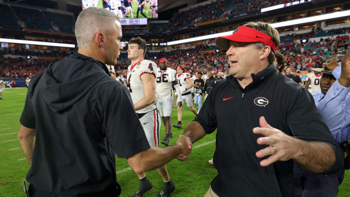 Dec 30, 2023; Miami Gardens, FL, USA; Georgia Bulldogs head coach Kirby Smart (right) shakes hands with Florida State Seminoles head coach Mike Norvell (left) after the 2023 Orange Bowl at Hard Rock Stadium. Mandatory Credit: Nathan Ray Seebeck-USA TODAY Sports