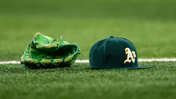 Jul 22, 2025; Arlington, Texas, USA;  Athletics glove and hat on the field before the game against the Texas Rangers at Globe Life Field. Mandatory Credit: Kevin Jairaj-Imagn Images