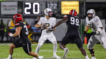 Aug 28, 2025; Orlando, Florida, USA; UCF Knights quarterback Tayven Jackson (2) rolls back to pass as Jacksonville State Gamecocks defensive end Emmanuel Oyebadejo (99) moves in during the second quarter at Acrisure Bounce House. Mandatory Credit: Mike Watters-Imagn Images