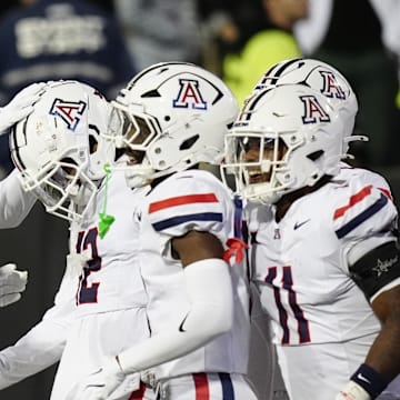 Nov 1, 2025; Boulder, Colorado, USA; Arizona Wildcats defensive back Genesis Smith (12) (center) celebrates his interception with teammates in the second half against the Colorado Buffaloes at Folsom Field. Mandatory Credit: Ron Chenoy-Imagn Images