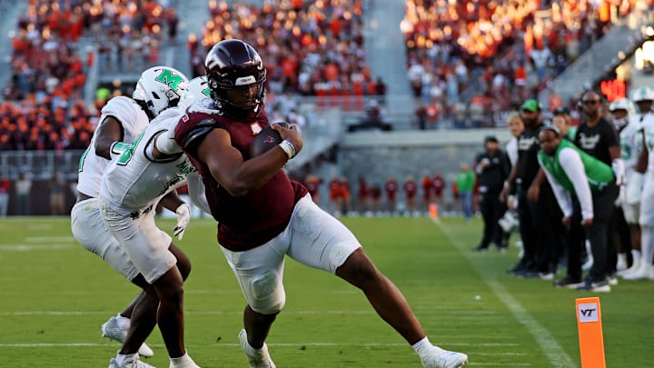 Sep 7, 2024; Blacksburg, Virginia, USA; Virginia Tech Hokies quarterback Kyron Drones (1) run for a touchdown during the third quarter against Marshall Thundering Herd cornerback Jacobie Henderson (10) at Lane Stadium. Mandatory Credit: Peter Casey-Imagn Images