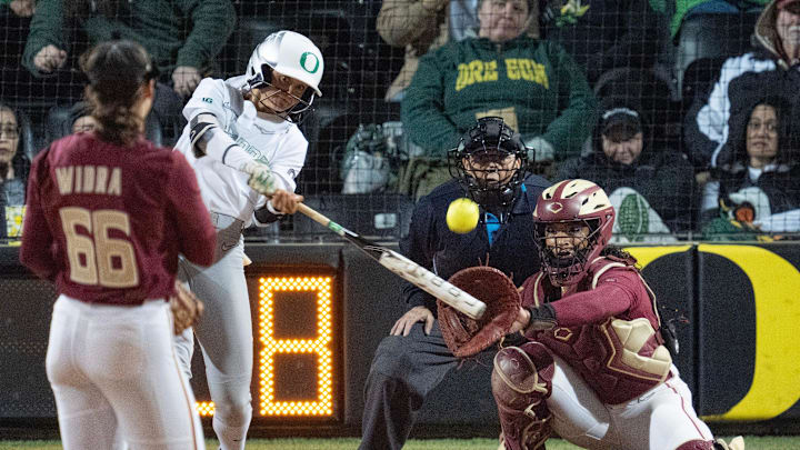 Oregon’s Kedre Luschar, center, gets a hit against Florida State’s pitcher Annabelle Widra during the Jane Sanders Classic softball tournament in Eugene Friday, March 7, 2025.