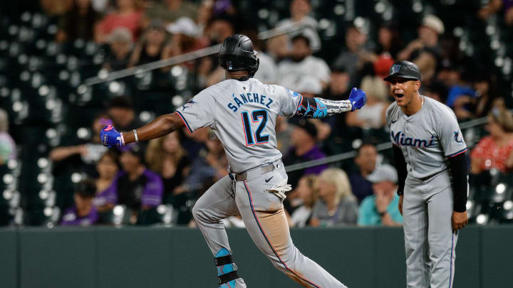 Miami Marlins left fielder Jesus Sanchez (12) gestures to first base coach Jon Jay (11) on a three run home run in the ninth inning against the Colorado Rockies at Coors Field on Aug 27.