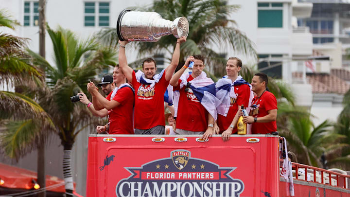 Jun 30, 2024; Fort Lauderdale, Florida, USA; Florida Panthers center Aleksander Barkov (center) hoists the cup during the Stanley Cup victory parade and celebration. Mandatory Credit: Sam Navarro-Imagn Images
