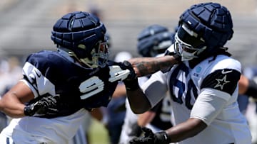Jul 30, 2024; Oxnard, CA, USA; Dallas Cowboys defensive end Marshawn Kneeland (94) and offensive tackle Tyler Guyton (60) battle during training camp at the River Ridge Playing Fields in Oxnard, California. Mandatory Credit: Jason Parkhurst-Imagn Images