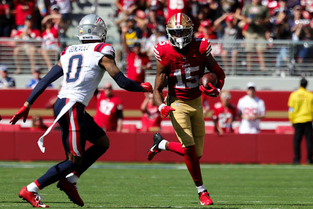 San Francisco 49ers wide receiver Jauan Jennings (15) runs the ball against New England Patriots cornerback.
