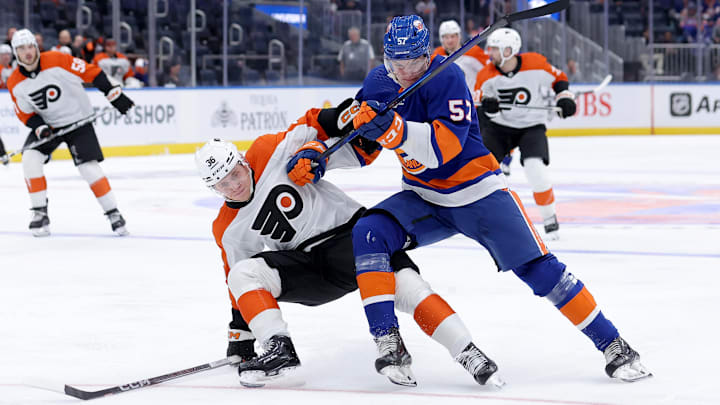 Sep 27, 2023; Elmont, New York, USA; New York Islanders left wing Eetu Liukas (57) and Philadelphia Flyers defenseman Emil Andrae (36) fight for the puck during the second period at UBS Arena. Mandatory Credit: Brad Penner-USA TODAY Sports